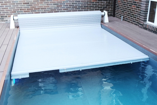 A pool with a covered surface and a ladder placed on top, providing access to the pool.