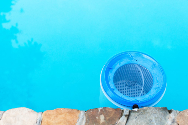 Blue bucket on pool surface, ready for use.