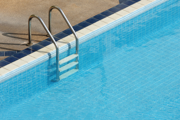 A ladder placed in the center of a swimming pool, providing access to and from the water.