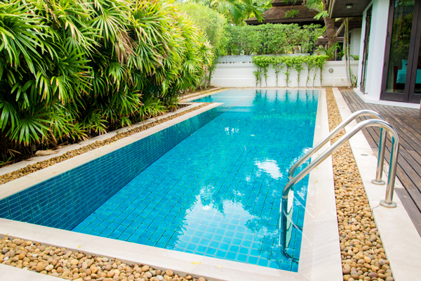 A backyard oasis featuring a small pool surrounded by a wooden deck.